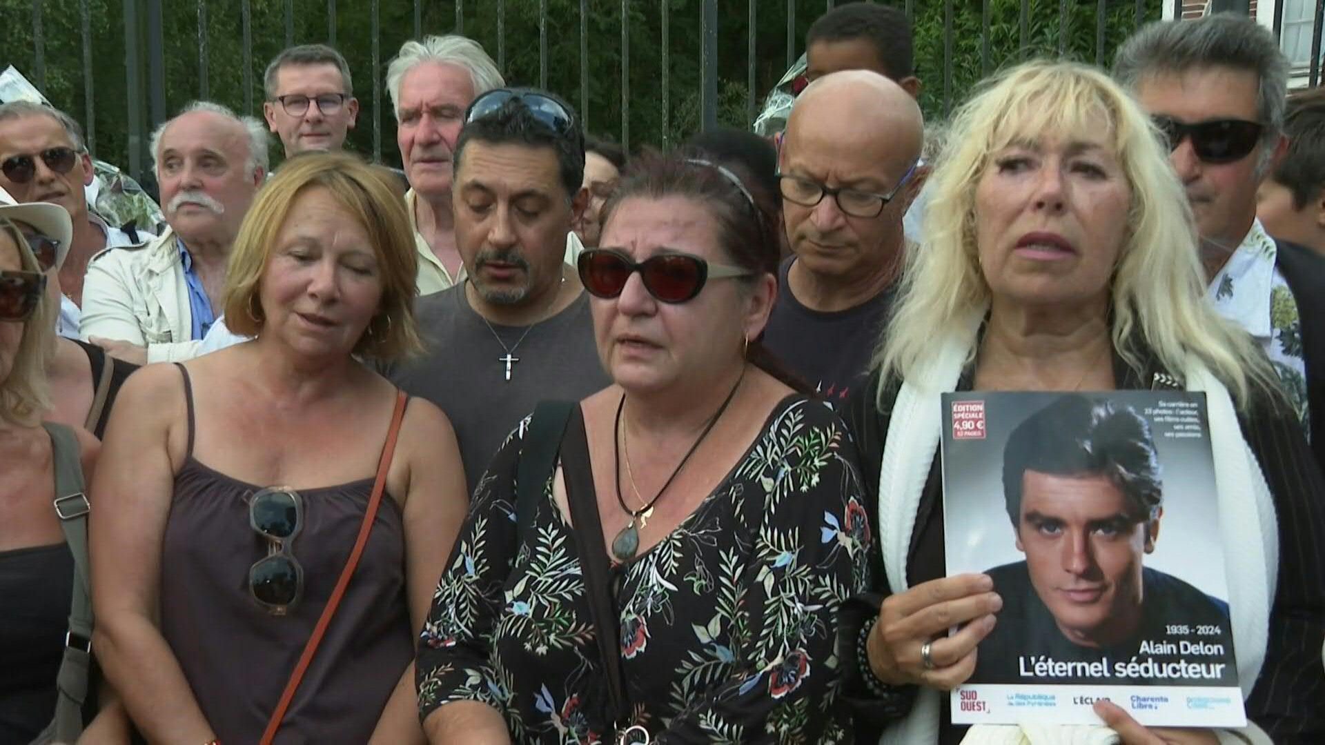 Mourning fans sing 'Paroles, paroles' outside French actor Alain Delon's estate