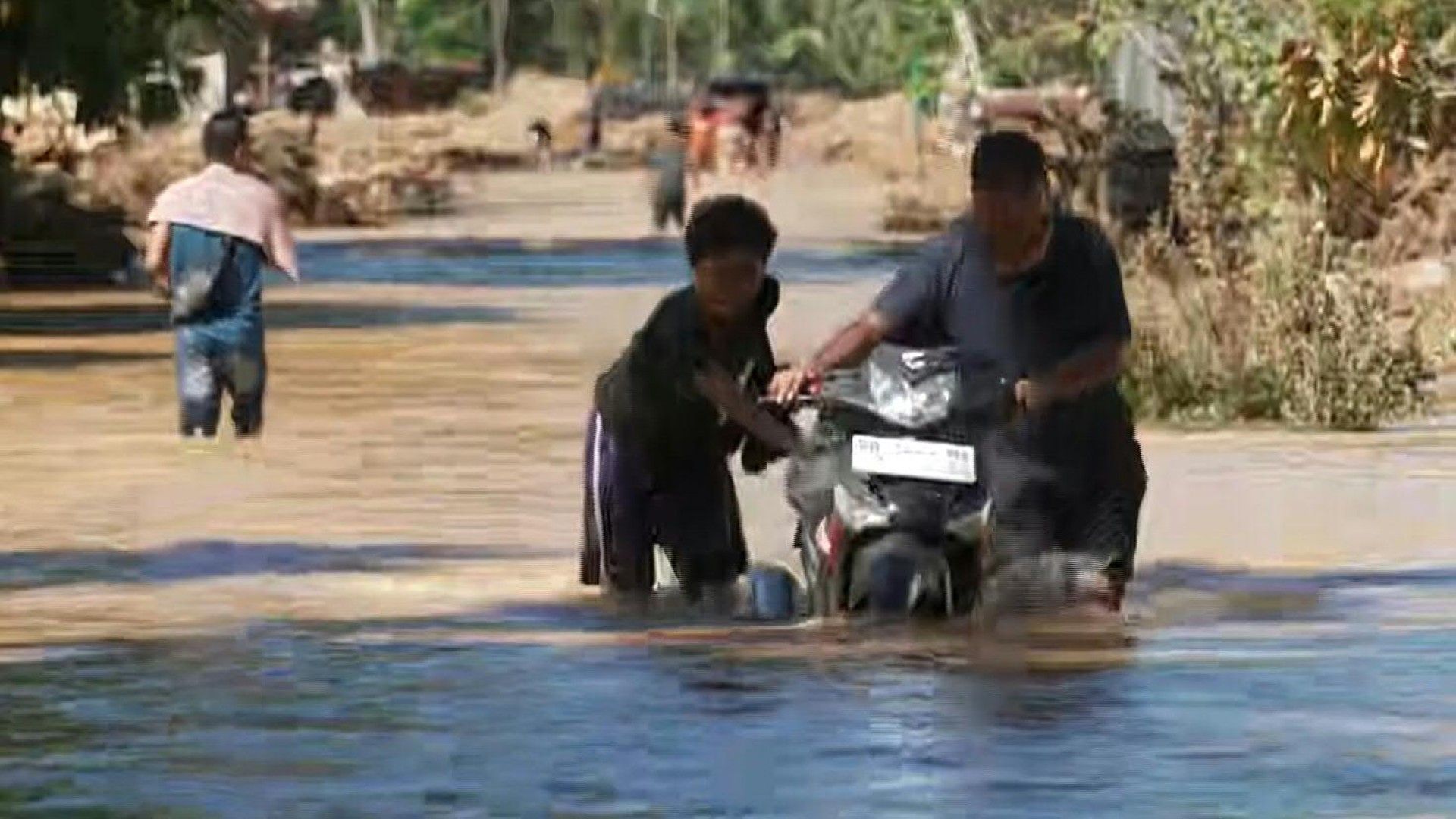 People-wade-through-floodwater-on-Indonesia-s-Sumatra-as-death-toll-rises-to-712