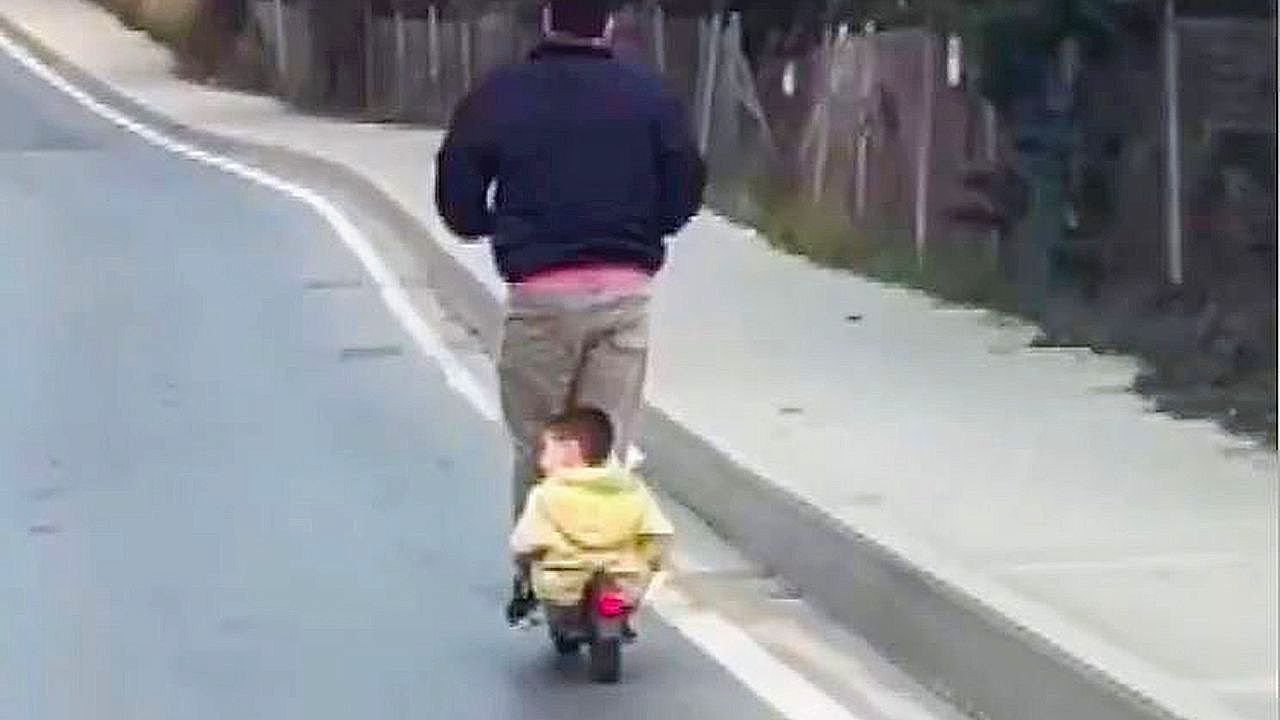 Video: Man caught in risky roadside moment with child aboard scooter