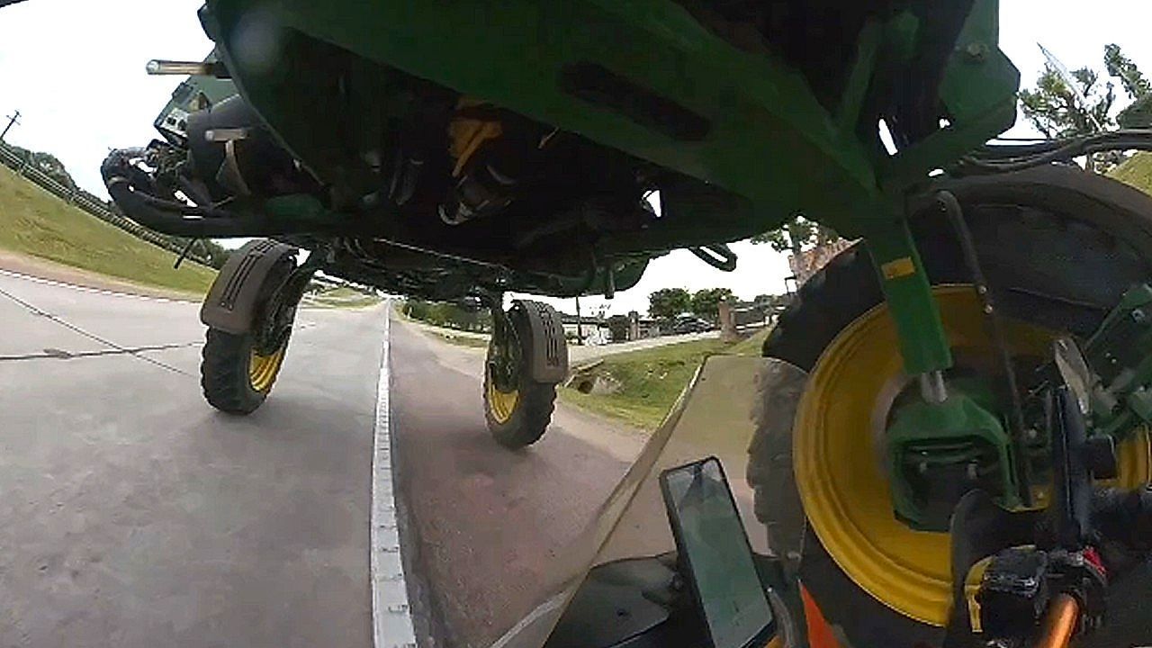 Video: Motorcyclist pulls off risky ride under moving tractor