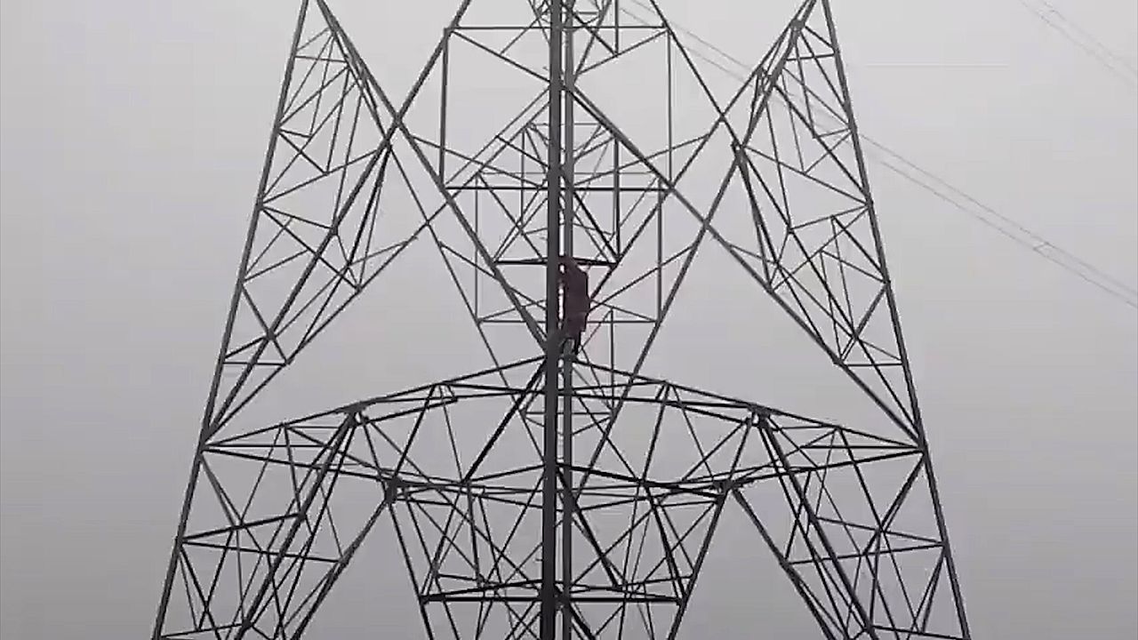 Love drama unfolds atop electricity tower as woman refuses to climb down without marriage promise