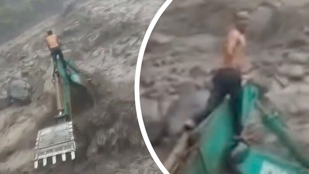 Video: Inmitten der Fluten: Arbeiter rettet sich vor reißendem Wasser auf Bagger