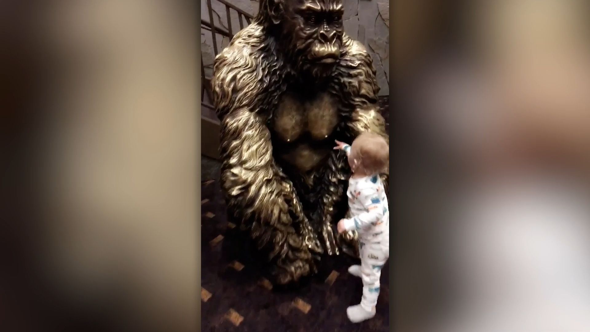 Baby wants to be breastfed by gorilla statue